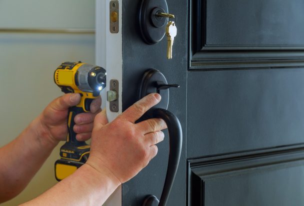 closeup-of-a-professional-locksmith-installing-a-new-lock-on-a-house-exterior-door-with-the-inside.jpg